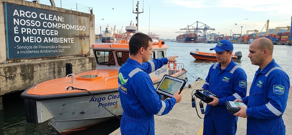Equipe da Argo Clean recebendo briefing operacional junto a embarcação de resposta ambiental